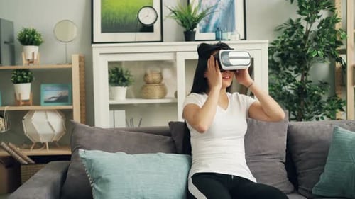 Woman Using VR Headset at Home on Couch