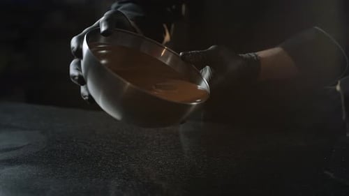 Pouring Melted Chocolate from Bowl in Kitchen