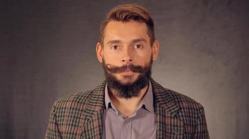 Bearded Man Smiles with Positive Expression