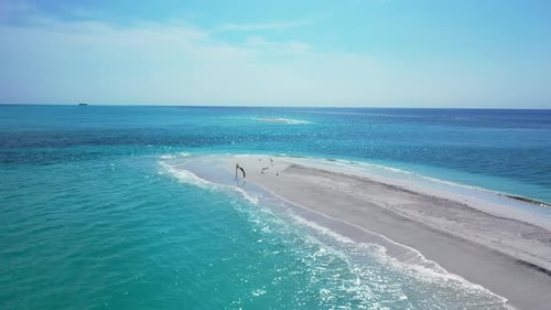 Wide angle birds eye tourism shot of a white paradise beach and blue water background in hi res 4K