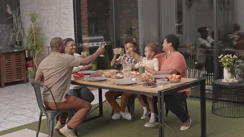 Happy Family Enjoying Outdoor Meal With Toast