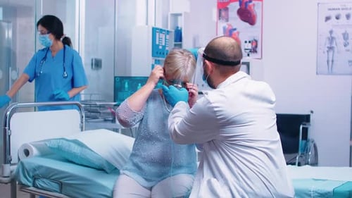Senior Woman Receiving Oxygen Mask From Doctor