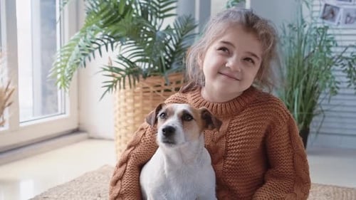 Little Girl Hugging Her Dog Inside Home