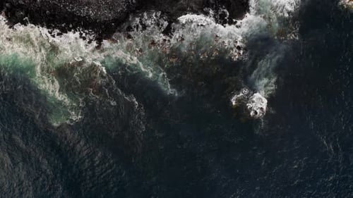 Stone Beach and Waves Crashing Over Big Volcanic Rocks