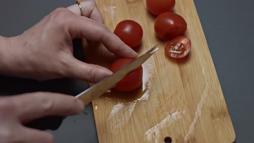 Cutting Cherry Tomatoes on Wooden Cutting Board