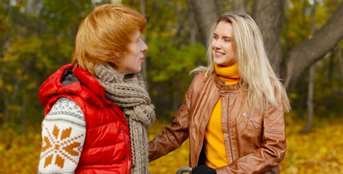 Woman and Young Adult Talking in Autumn Park