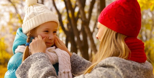 Mother Bundling Daughter in Scarf During Fall