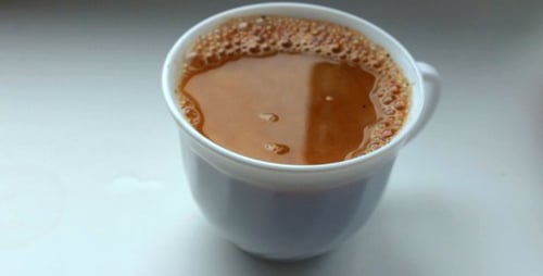Cream Added To Coffee In White Mug