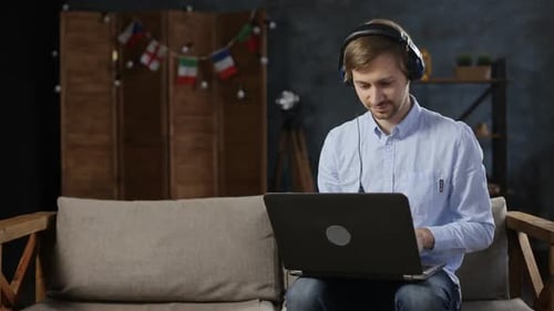 Young Adult Working on Laptop with Headphones Indoors