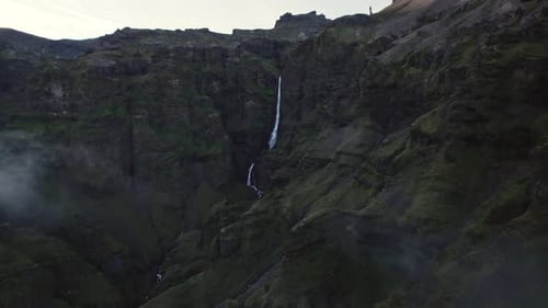 Majestic Waterfall Cascades Down Rugged Mountain