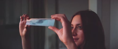 Woman photographer looking at her film strip close up