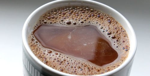 Pouring Milk into Coffee Cup in Close Up