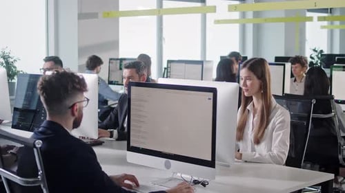 Espace ouvert de bureaux d'entreprise moderne avec un personnel multiculturel occupé, un groupe d'employés utilisant des ordinateurs PC