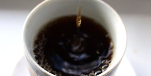 Dark Liquid Pouring Into Teacup Close Up