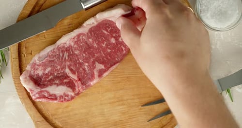 Raw Steaks Placed on Cutting Board for Cooking