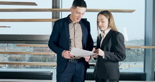 Man and a Woman Discussing Work in the Brightly Lit Modern Office. Concerned Male and Female Working