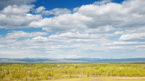 Scenic Wide Shot of Rural Landscape Under Cloudy Sky
