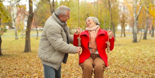 Senior Couple on Swing in Beautiful Autumn Park