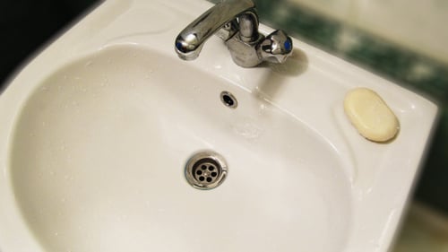 Hands Washing in a White Sink Close Up