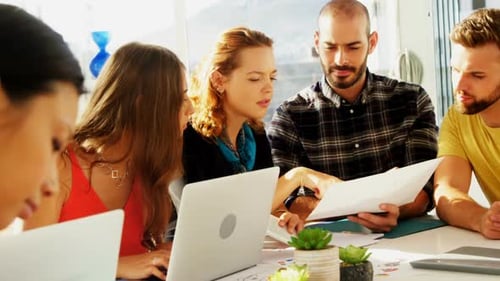 Team of executives interacting with each other while working in the office