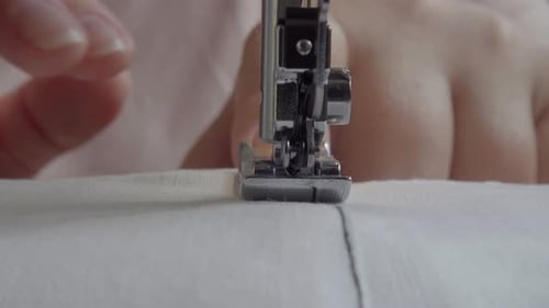 Nähmaschine mit Stoff und Faden, Nahaufnahme.