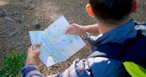 Male hiker looking at map in the forest 4k
