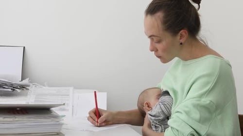 Woman Feeding Baby and Using Working