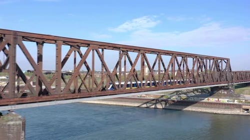 Commuter Train Passing Fast Over an Old Iron Bridge