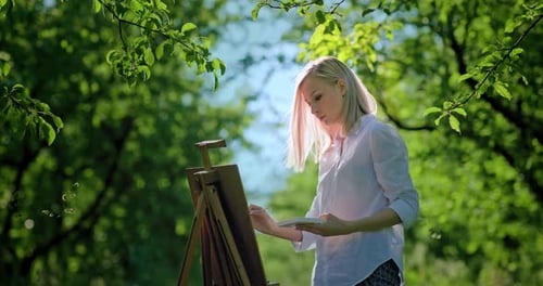 Female Artist Painting Outdoors in Nature