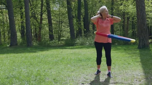 Senior Elderly Woman Female Doing Hula Hoop Exercises Sport in Park Sunny Day