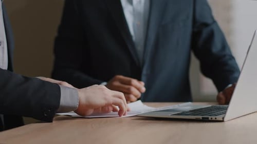Closeup Two Multiethnic Unrecognizable Business Men Sitting in Office with Papers Sign Contract