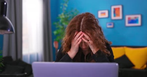 Distressed Young Woman Using Laptop Indoors