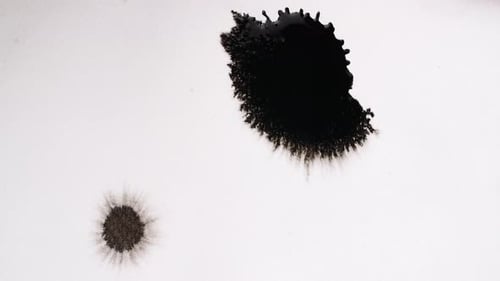 Black Ink Spreading on White Surface
