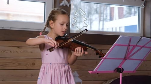 Girl Plays Violin in Cozy Room