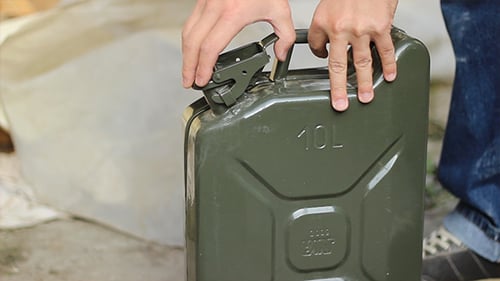 Opening a green jerry can for gasoline