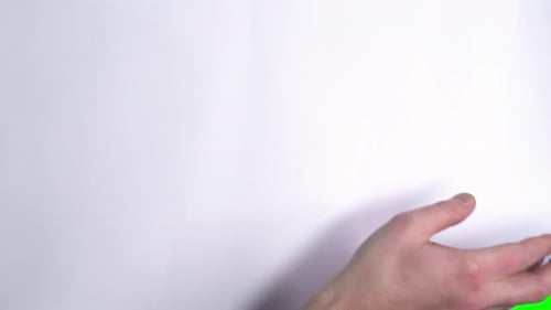 Male Hand Flips a White Sheet of Paper on a Green Screen.