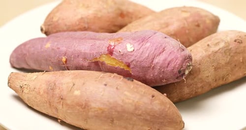 Close-Up of Fresh Sweet Potatoes on White Plate