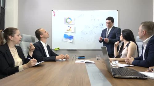 Business Team Meeting at Conference Table With Whiteboard