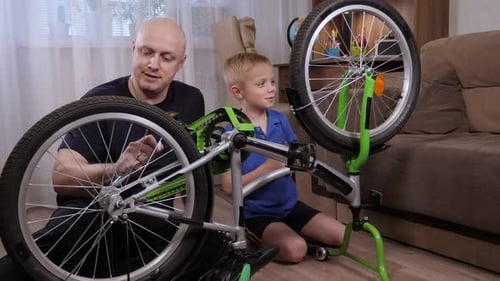 Father and Son Repairing Bicycle Together at Home