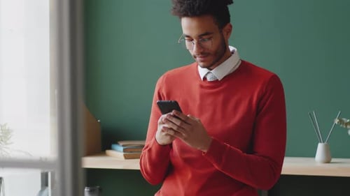 Handsome Mixed Race Man Typing on Smartphone in Office