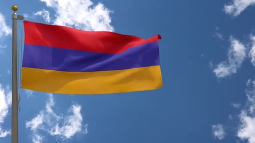 Armenian Flag Waving on Flagpole Against Blue Sky with Clouds