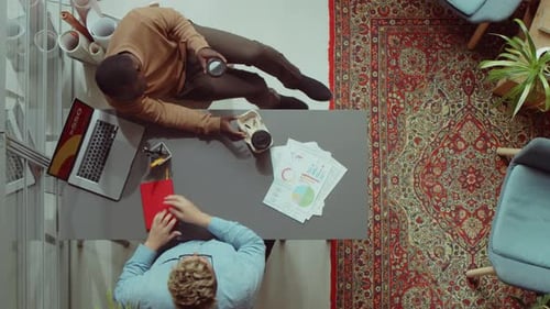 Male Colleagues Talking over Coffee in Office