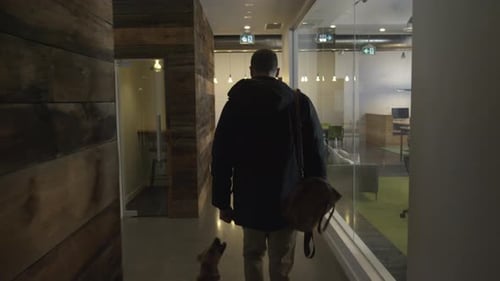 Man and Dog Walking Through Modern Office