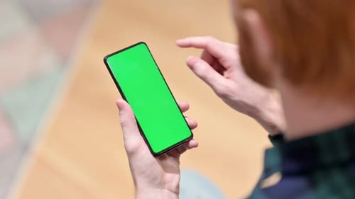 Young Man Using Smartphone with Chroma Key Screen
