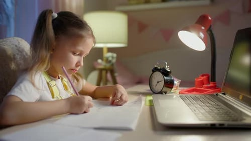 Girl Doing Homework at Desk at Night