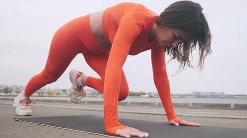 Young Woman Doing Mountain Climber Exercise Outdoors