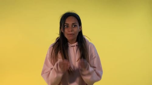 Woman Expressing Emotions Against a Yellow Backdrop