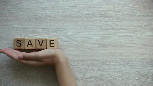 Hand Spells Out Save Planet With Wooden Blocks