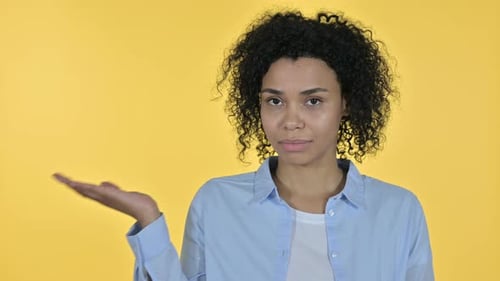 Woman Presenting Against a Yellow Background
