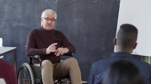 Mature Teacher Lecturing Students in Classroom Setting